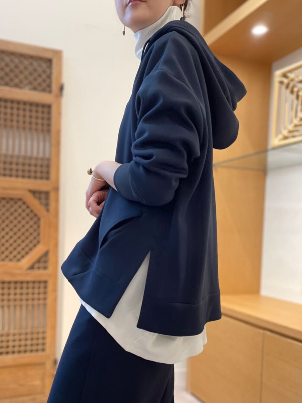 ホワイト系のニット/セーター、ブルー系のスカート、ホワイト系のスニーカーを着用したレディースの春コーディネートの2枚目の写真