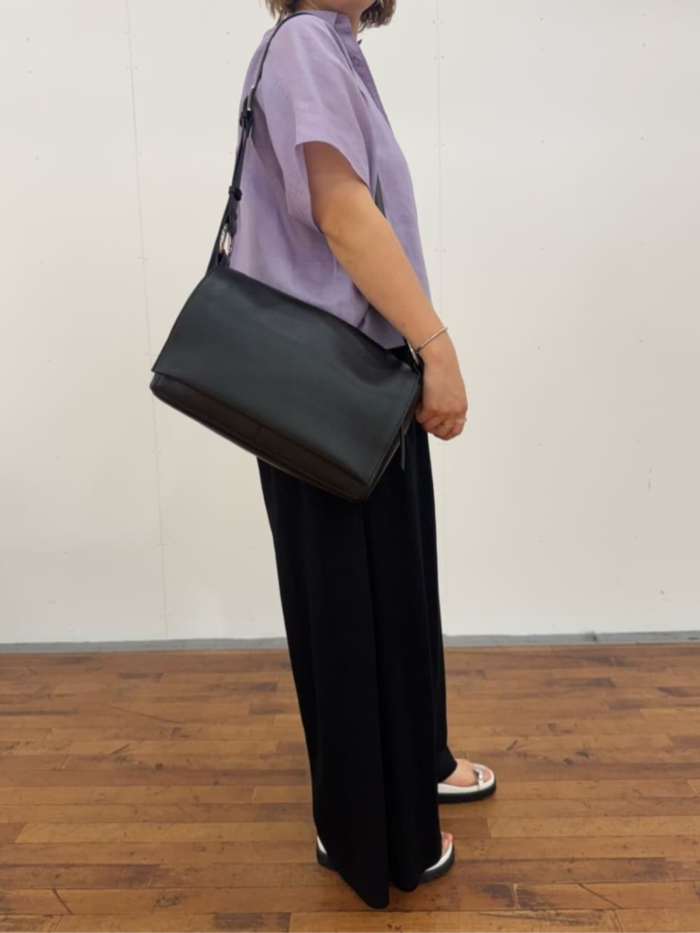 ブラック系のその他パンツ、ホワイト系のサンダル、ブラック系のショルダーバッグを着用したレディースの春コーディネートの7枚目の写真