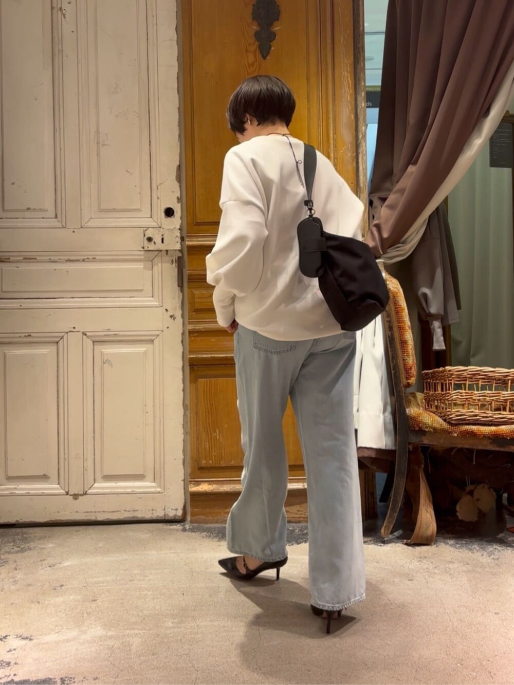 ブルー系のデニムパンツ、ホワイト系のTシャツ/カットソー、ブラック系のショルダーバッグを着用したレディースの冬コーディネートの8枚目の写真