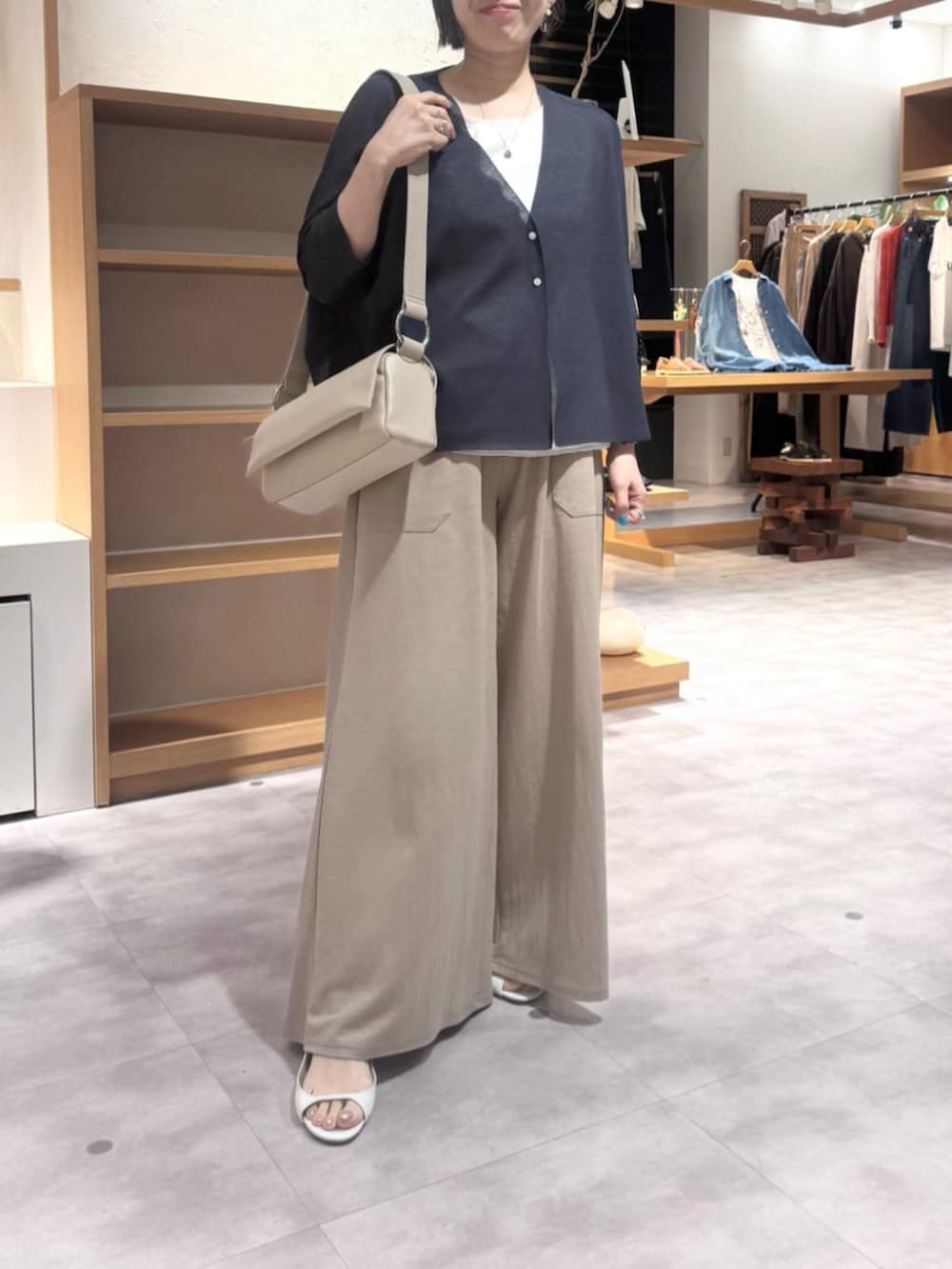 ベージュ系のその他パンツ、ベージュ系のショルダーバッグ、ブルー系のカーディガン/ボレロを着用したレディースの春コーディネートの9枚目の写真