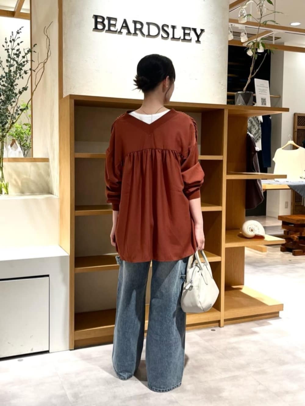 レッド系のシャツ/ブラウス、ブルー系のデニムパンツを着用したレディースの夏コーディネートの3枚目の写真