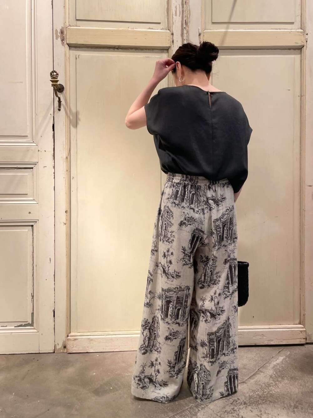 グレー系のシャツ/ブラウス、グレー系のその他パンツ、ブラック系のサンダルを着用したレディースの春コーディネートの2枚目の写真