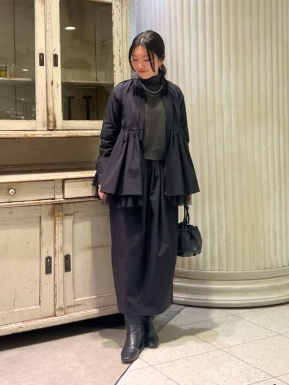 ブラック系のブルゾン、ブラック系のスカートを着用したレディースの冬コーディネートの2枚目の写真