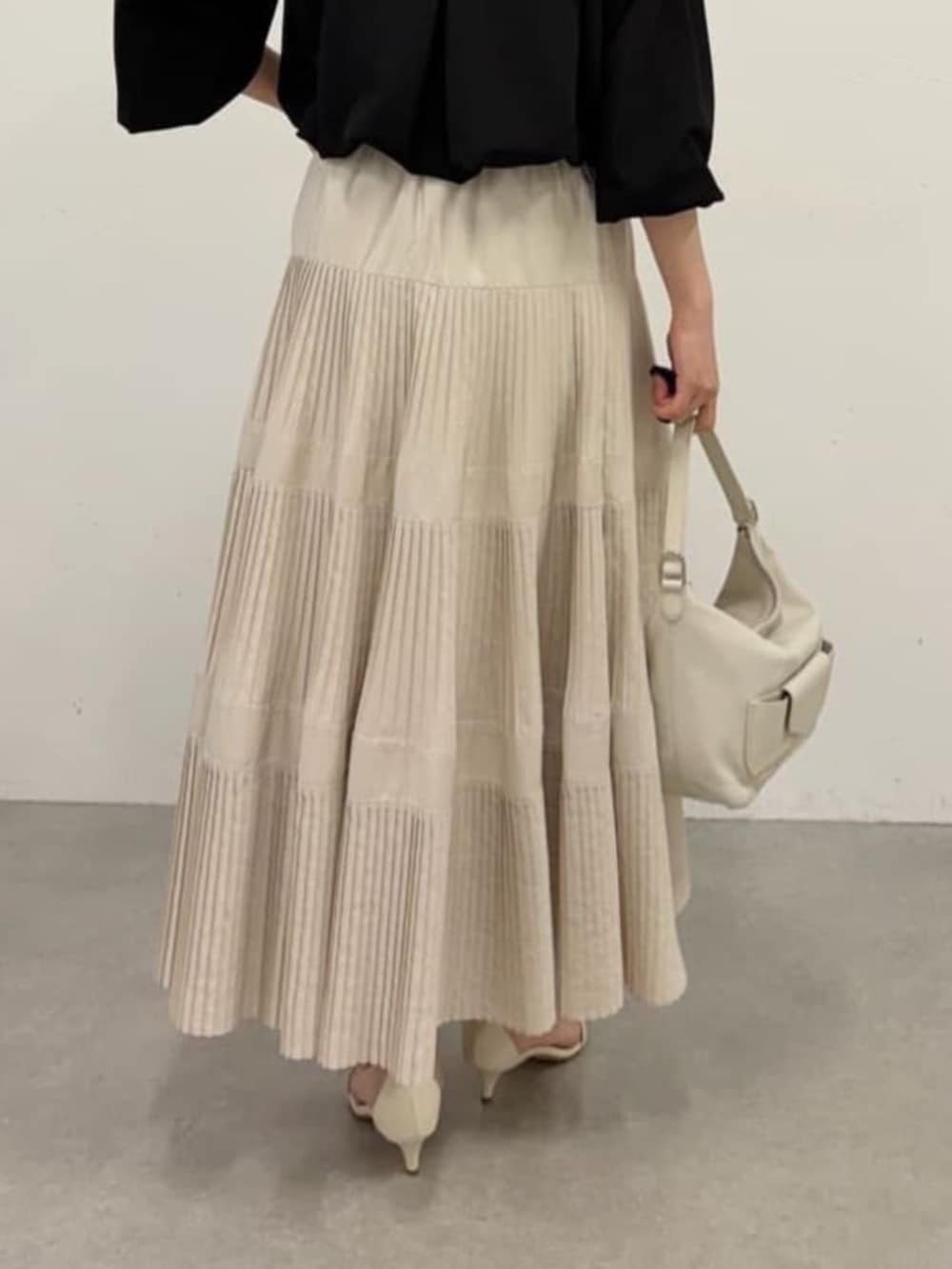 ホワイト系のスカート、ブラック系のシャツ/ブラウスを着用したレディースの春コーディネートの9枚目の写真