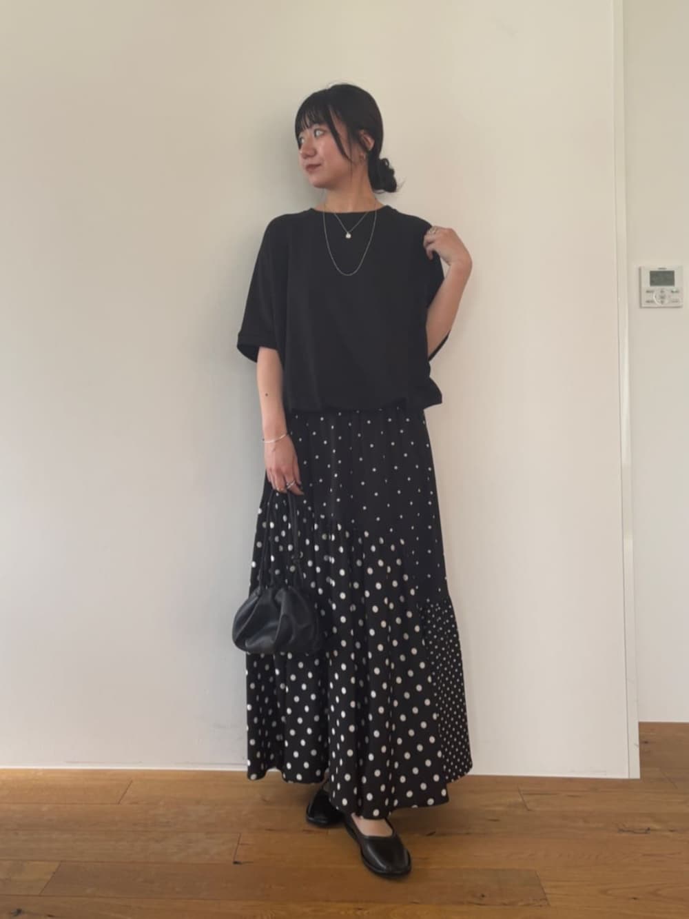 ブラック系のスカート、ブラック系のTシャツ/カットソーを着用したレディースの夏コーディネートの2枚目の写真