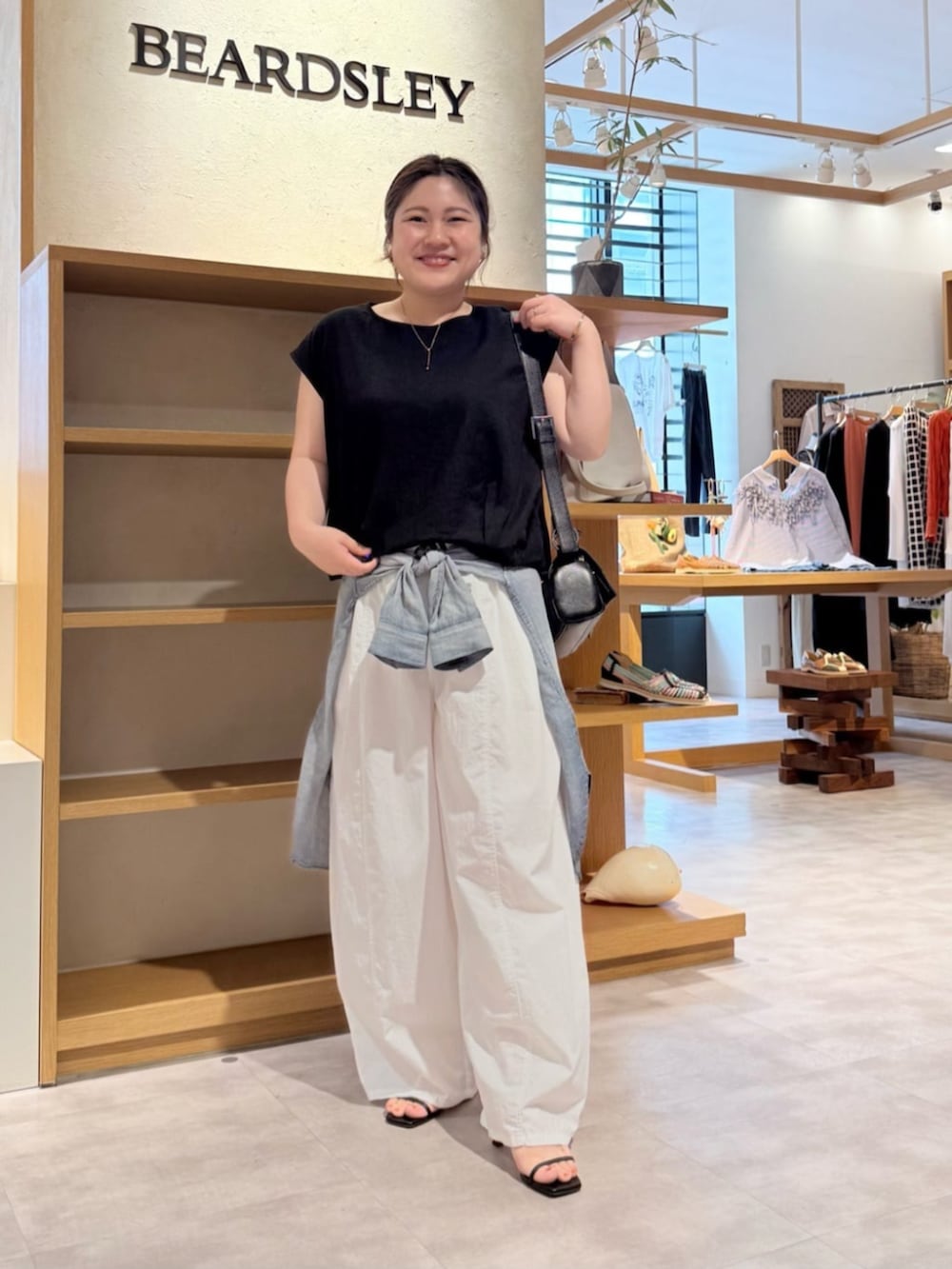 ブラック系のシャツ/ブラウス、ホワイト系のその他パンツを着用したレディースの春コーディネートの2枚目の写真