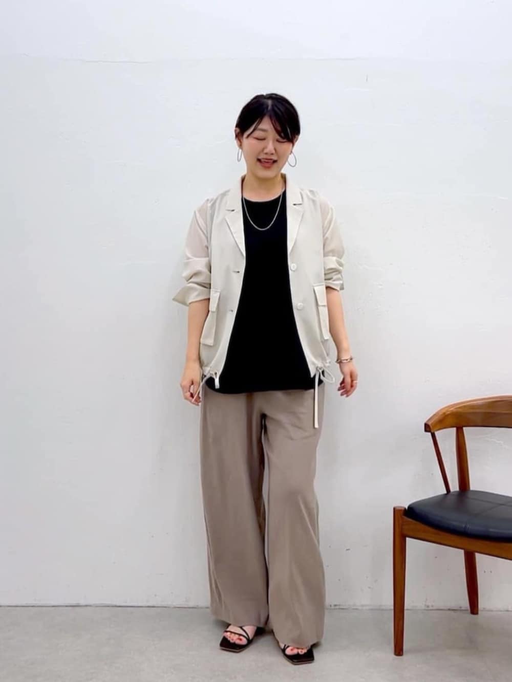 ブラック系のキャミソール、ホワイト系のブルゾン、グレー系のその他パンツを着用したレディースの夏コーディネートの7枚目の写真