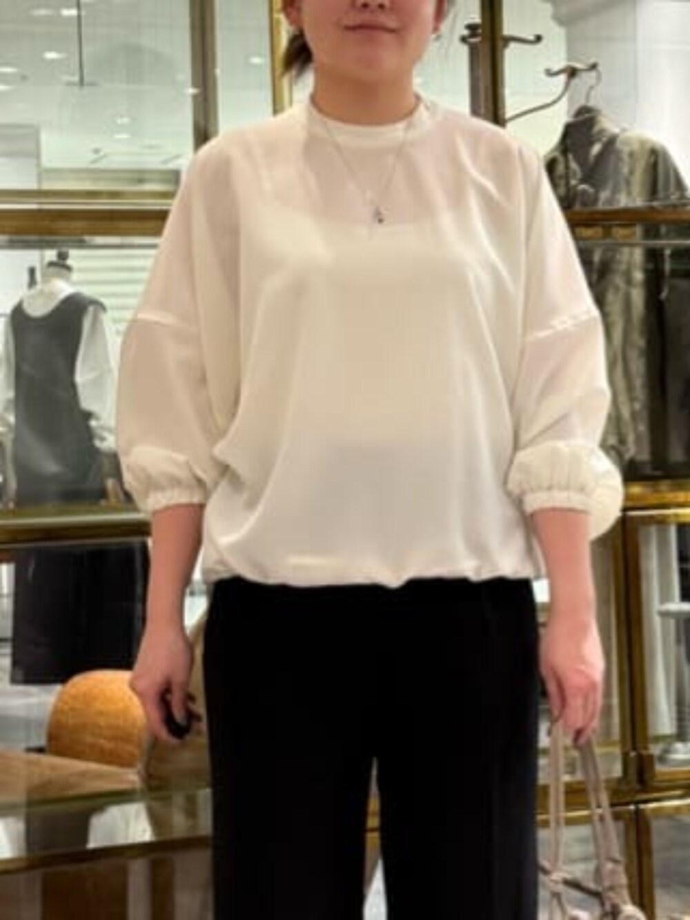 ベージュ系のショルダーバッグ、ホワイト系のシャツ/ブラウス、ブラック系のその他パンツを着用したレディースの冬コーディネートの4枚目の写真