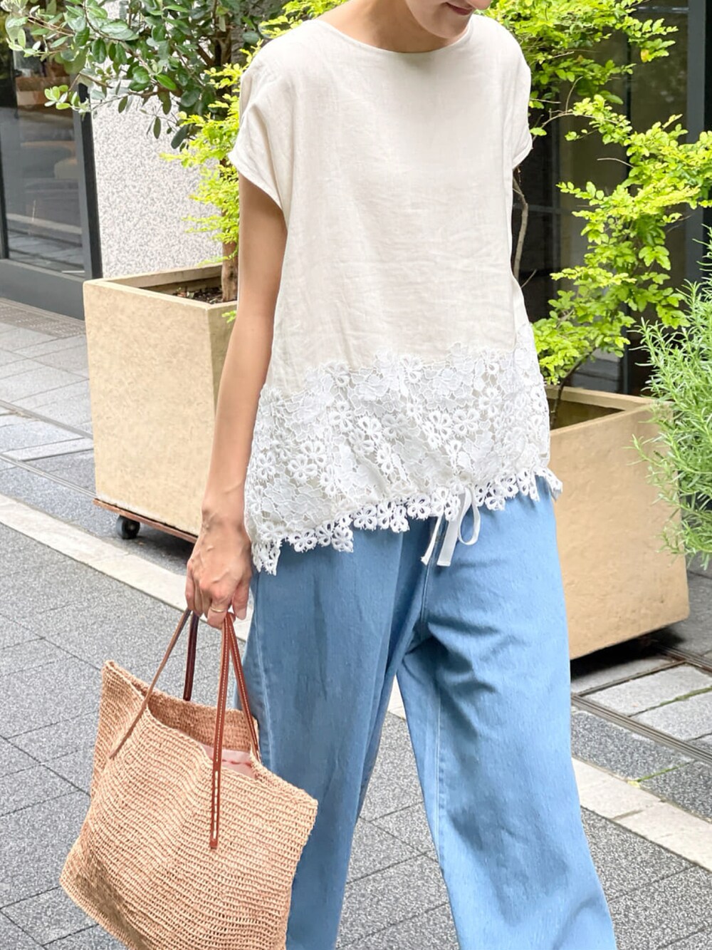 ベージュ系のシャツ/ブラウス、ブルー系のデニムパンツ、ベージュ系のかごバッグを着用したレディースの春コーディネートの3枚目の写真