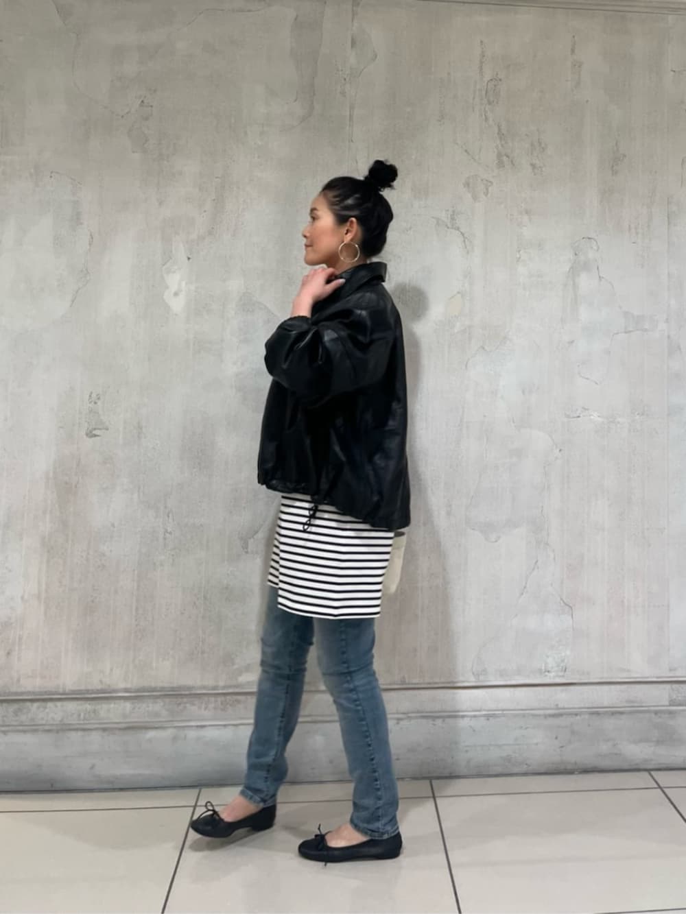 ブルー系のデニムパンツ、ブラック系のブルゾンを着用したレディースの冬コーディネートの4枚目の写真