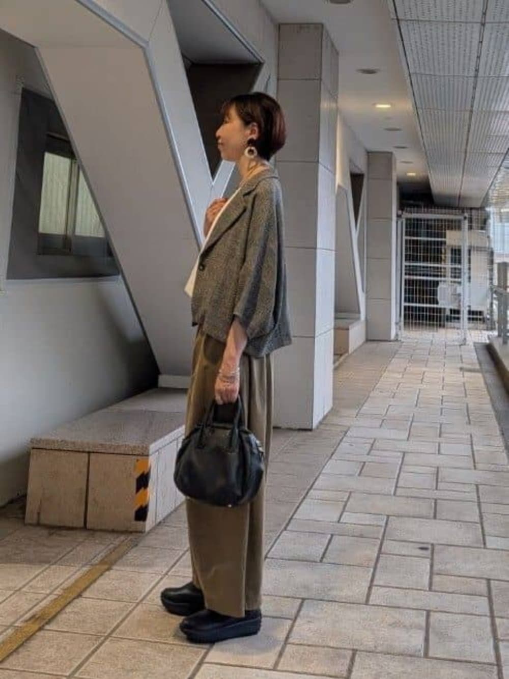 ブラック系のボストンバッグ、イエロー系のその他パンツ、ベージュ系のテーラードジャケットを着用したレディースの夏コーディネートの2枚目の写真