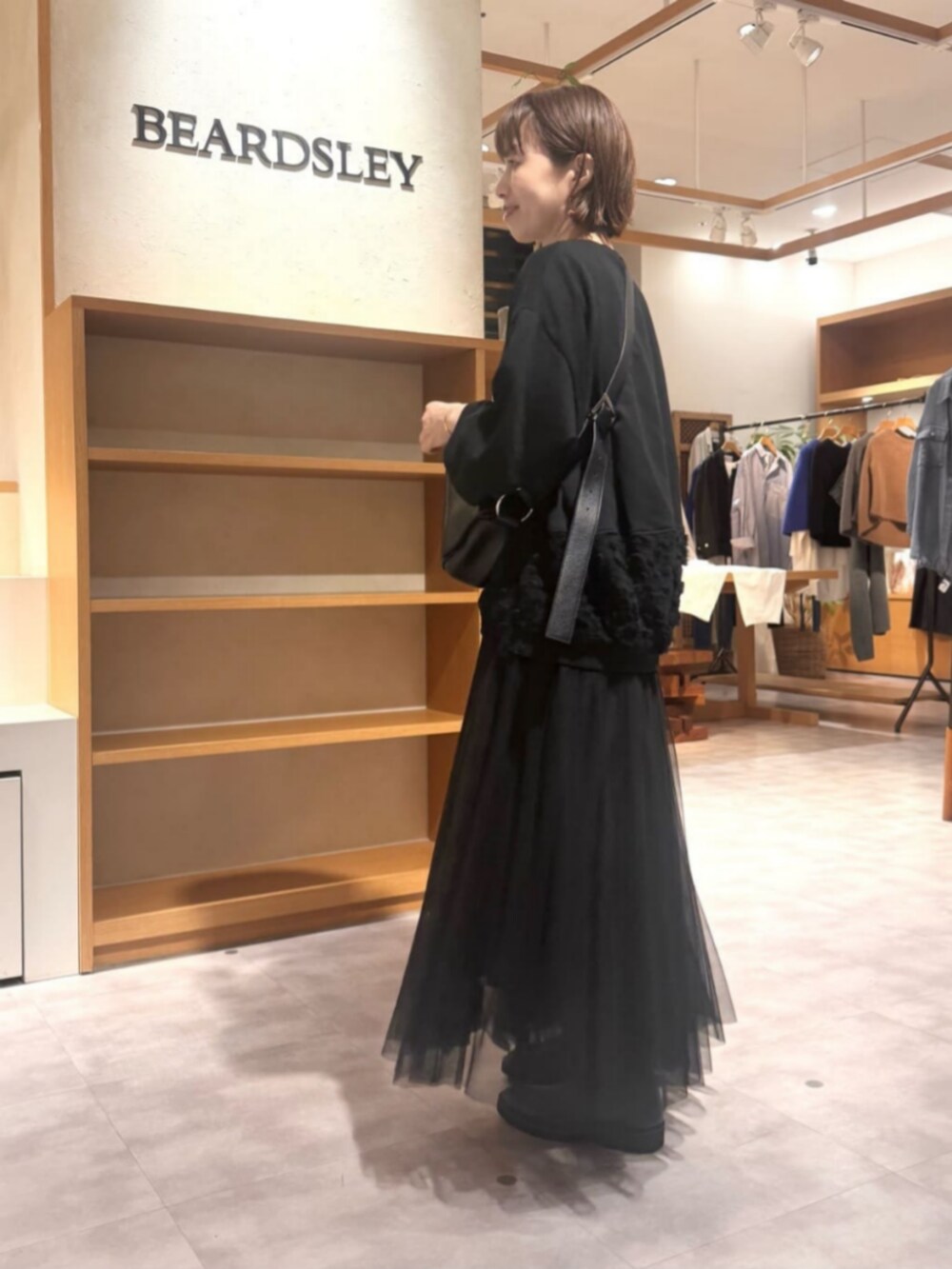 ブラック系のTシャツ/カットソー、ブラック系のスカートを着用したレディースの秋コーディネートの4枚目の写真