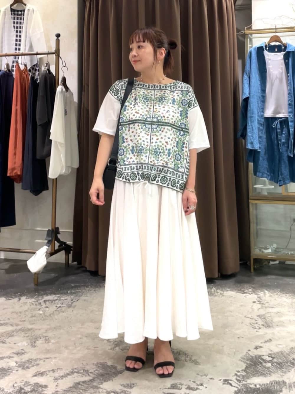 ホワイト系のスカート、ホワイト系のTシャツ/カットソーを着用したレディースの春コーディネートの2枚目の写真