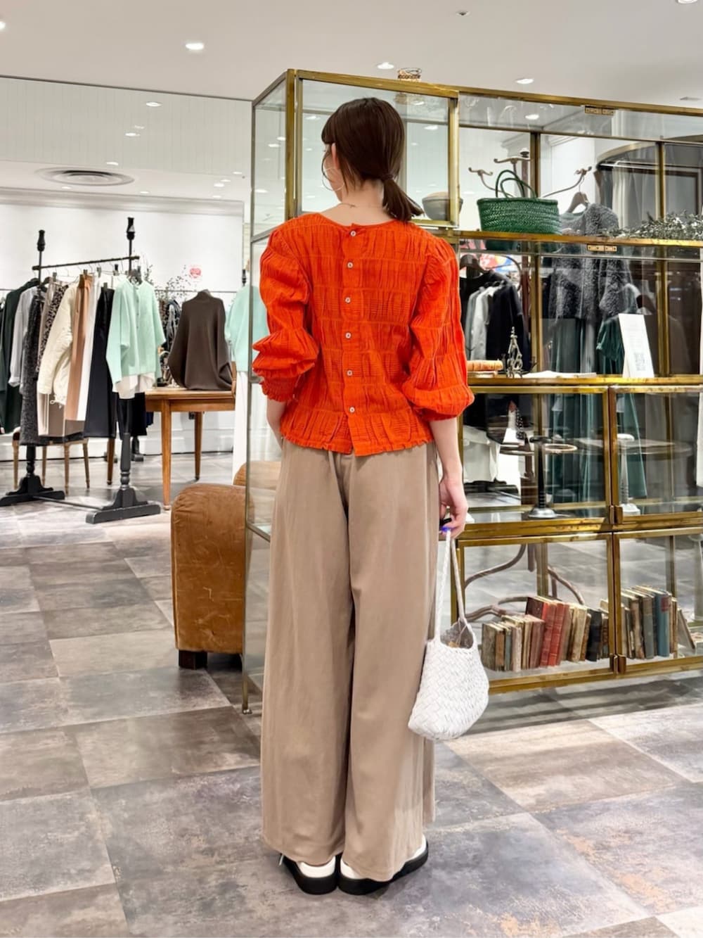 オレンジ系のシャツ/ブラウス、ベージュ系のその他パンツ、ホワイト系のサンダルを着用したレディースの春コーディネートの3枚目の写真