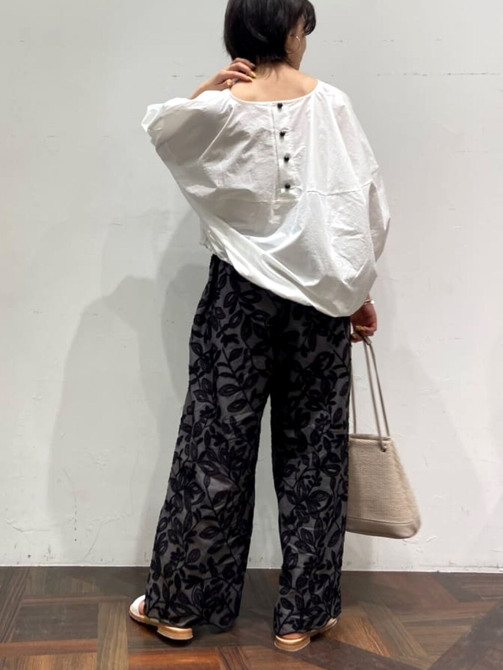 ホワイト系のシャツ/ブラウス、グレー系のその他パンツ、ベージュ系のトートバッグを着用したレディースの春コーディネートの2枚目の写真