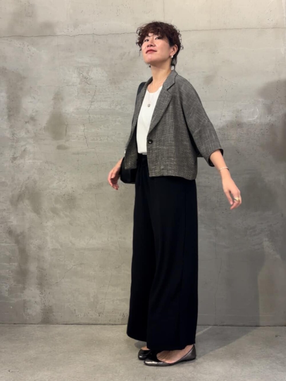 ホワイト系のタンクトップ、ベージュ系のテーラードジャケットを着用したレディースの春コーディネートの3枚目の写真