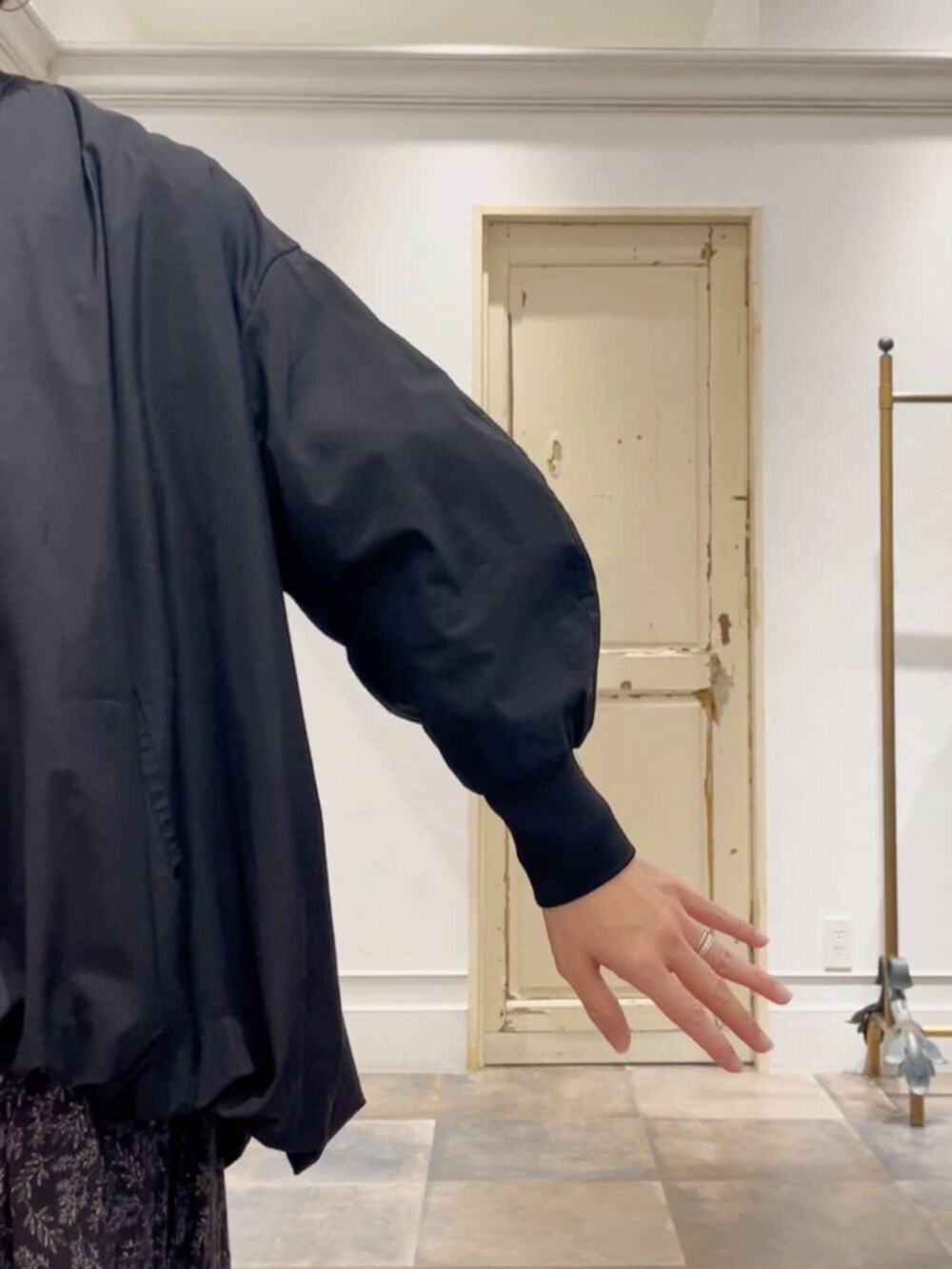 ブラック系のスカート、ベージュ系のショルダーバッグ、ブラック系のブルゾンを着用したレディースの冬コーディネートの8枚目の写真