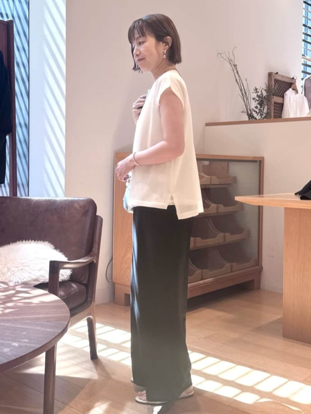 ホワイト系のニット/セーターを着用したレディースの夏コーディネートの2枚目の写真