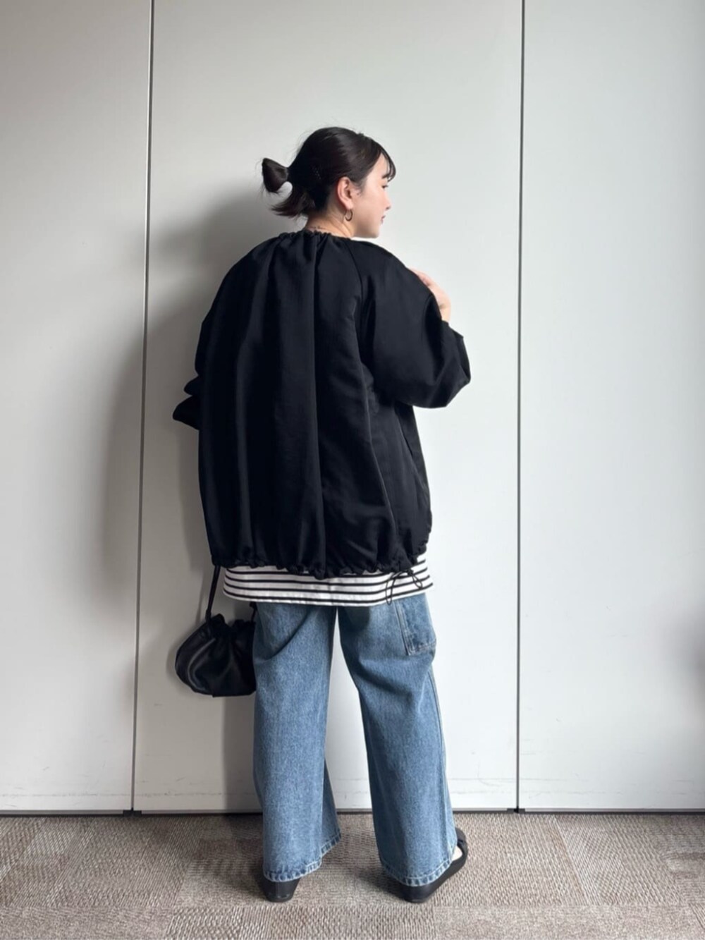 ブラック系のノーカラージャケット、ブルー系のその他パンツを着用したレディースの冬コーディネートの3枚目の写真
