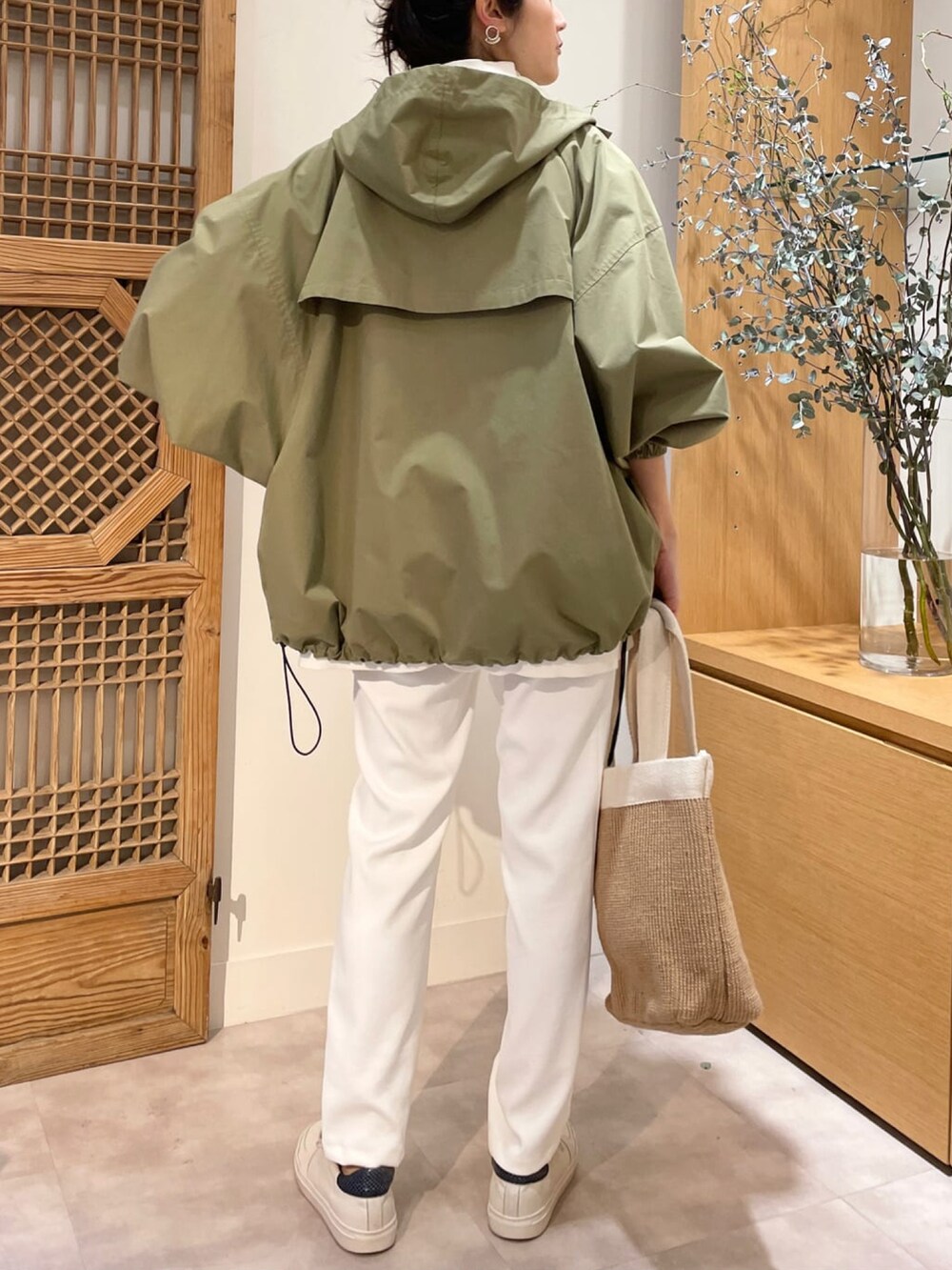 グリーン系のマウンテンパーカー、ホワイト系のニット/セーター、ホワイト系のその他パンツを着用したレディースの冬コーディネートの3枚目の写真