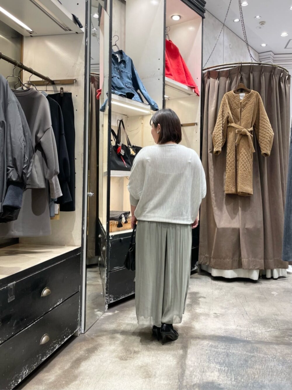 グレー系のニット/セーター、グリーン系のその他パンツ、ブラック系のトートバッグを着用したレディースの冬コーディネートの3枚目の写真