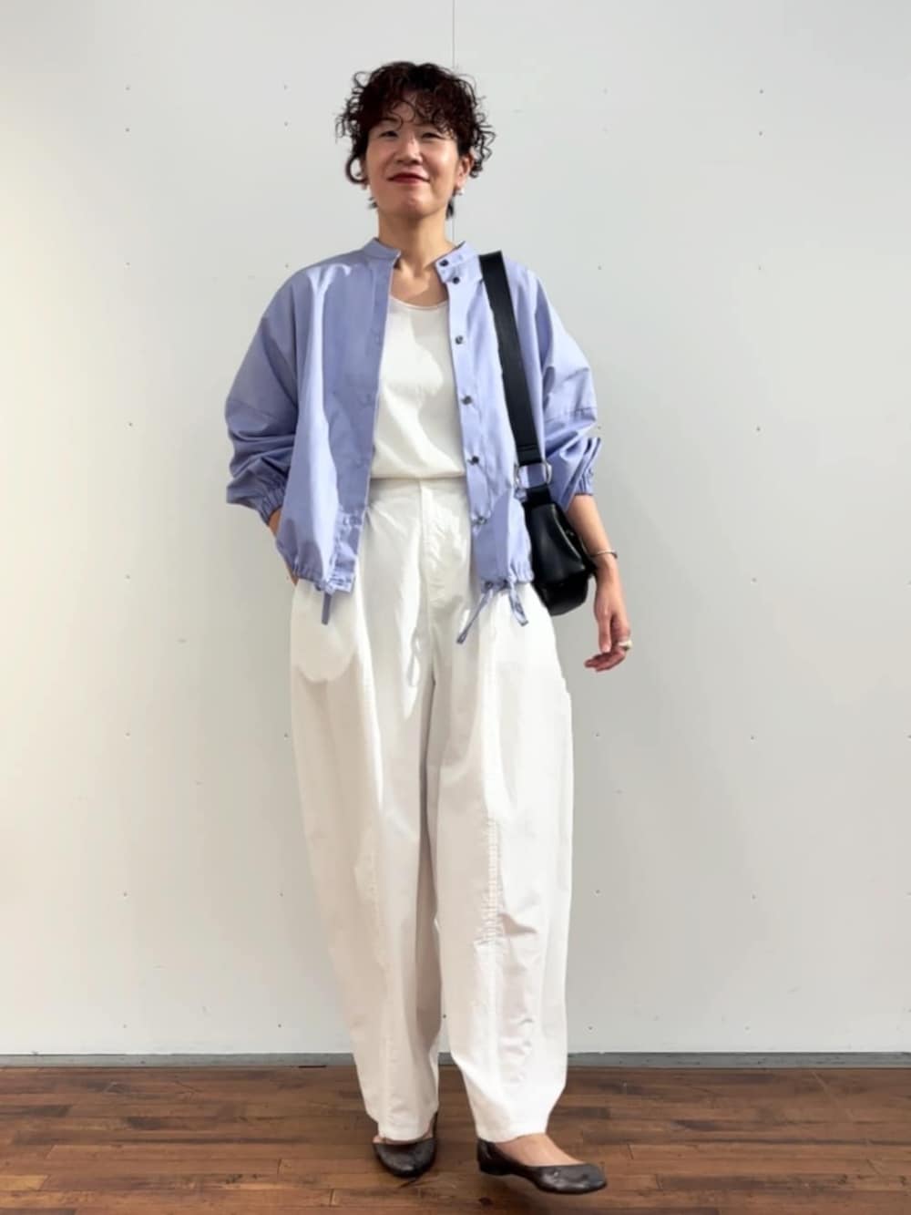 ホワイト系のタンクトップ、ブラック系のショルダーバッグ、ホワイト系のその他パンツを着用したレディースの冬コーディネートの3枚目の写真