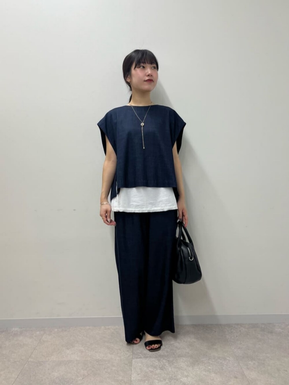 ブルー系のシャツ/ブラウス、ブルー系のその他パンツ、ブラック系のボストンバッグを着用したレディースの春コーディネートの2枚目の写真