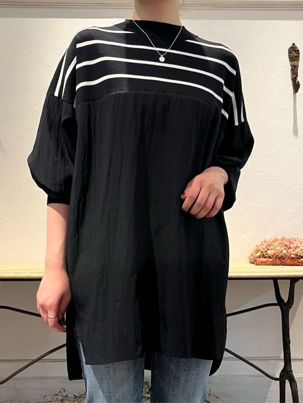 ブルー系のデニムパンツ、グレー系のハンドバッグ、ブラック系のニット/セーターを着用したレディースの冬コーディネートの5枚目の写真