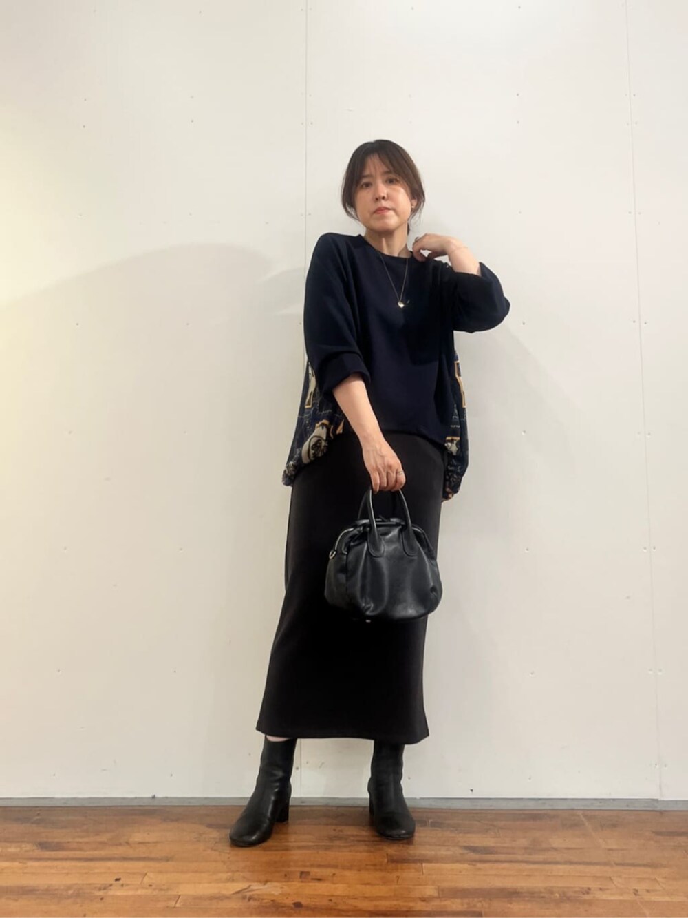 グレー系のスカート、ブラック系のトートバッグ、ブルー系のTシャツ/カットソーを着用したレディースの夏コーディネートの6枚目の写真