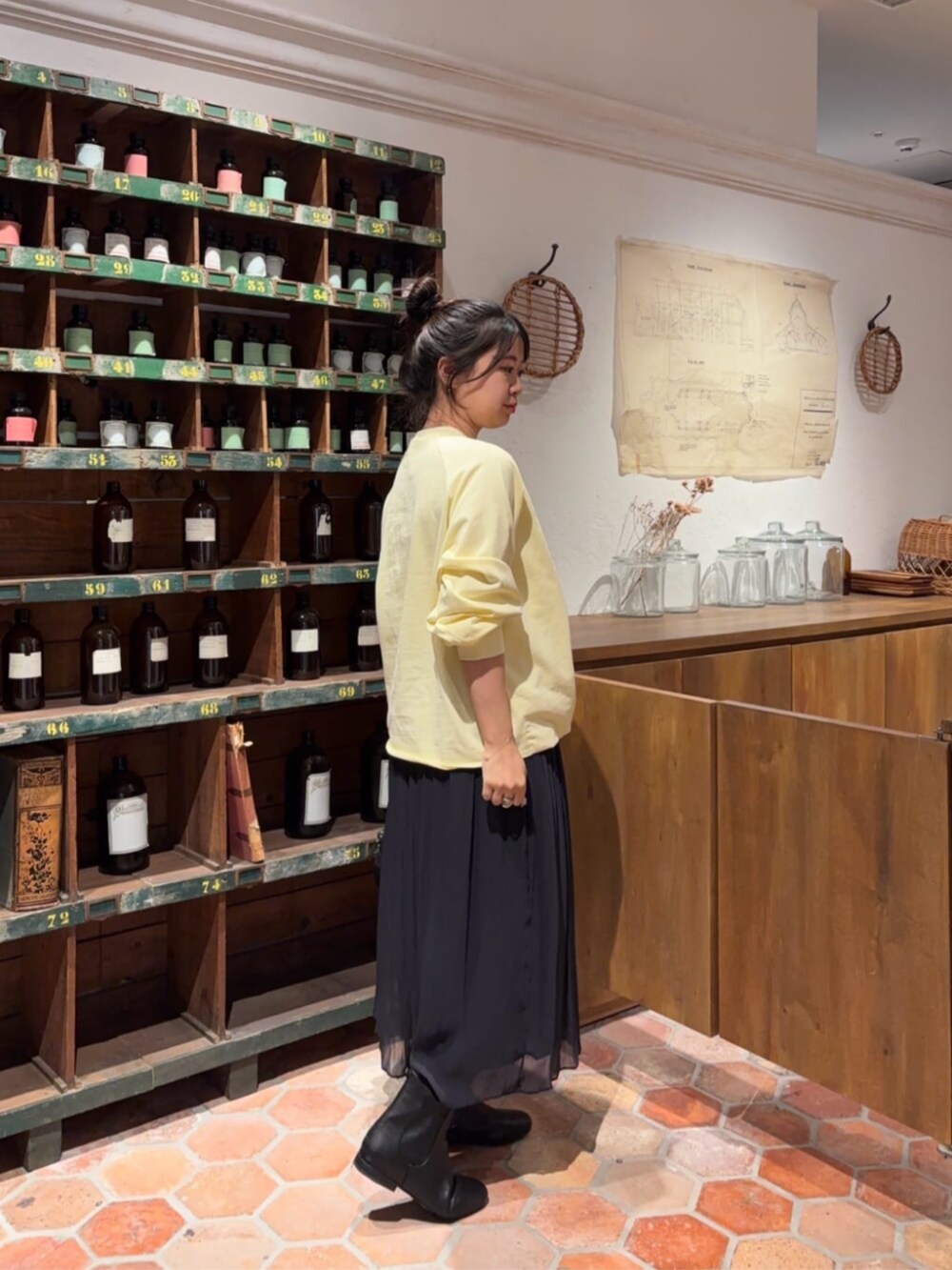 ブラック系のボストンバッグ、ブラック系のその他パンツ、イエロー系のTシャツ/カットソーを着用したレディースの冬コーディネートの2枚目の写真