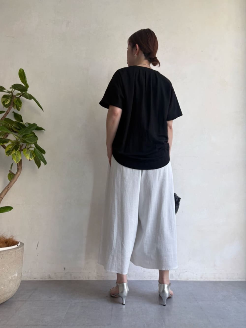 ブラック系のボストンバッグ、ホワイト系のその他パンツ、ブラック系のベストを着用したレディースの春コーディネートの6枚目の写真