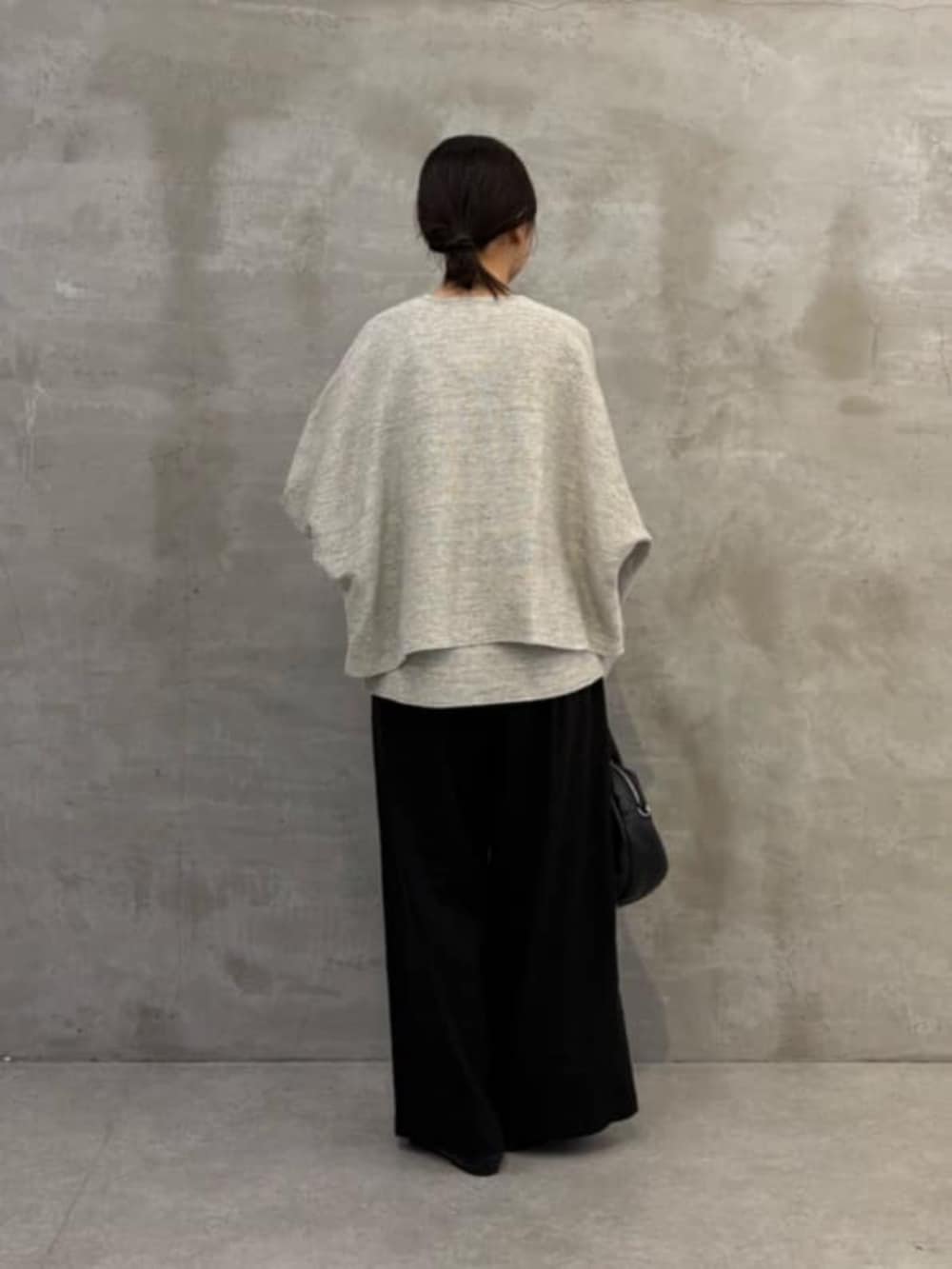 ブラック系のボストンバッグ、グレー系のニット/セーター、グレー系のカーディガン/ボレロを着用したレディースの春コーディネートの8枚目の写真