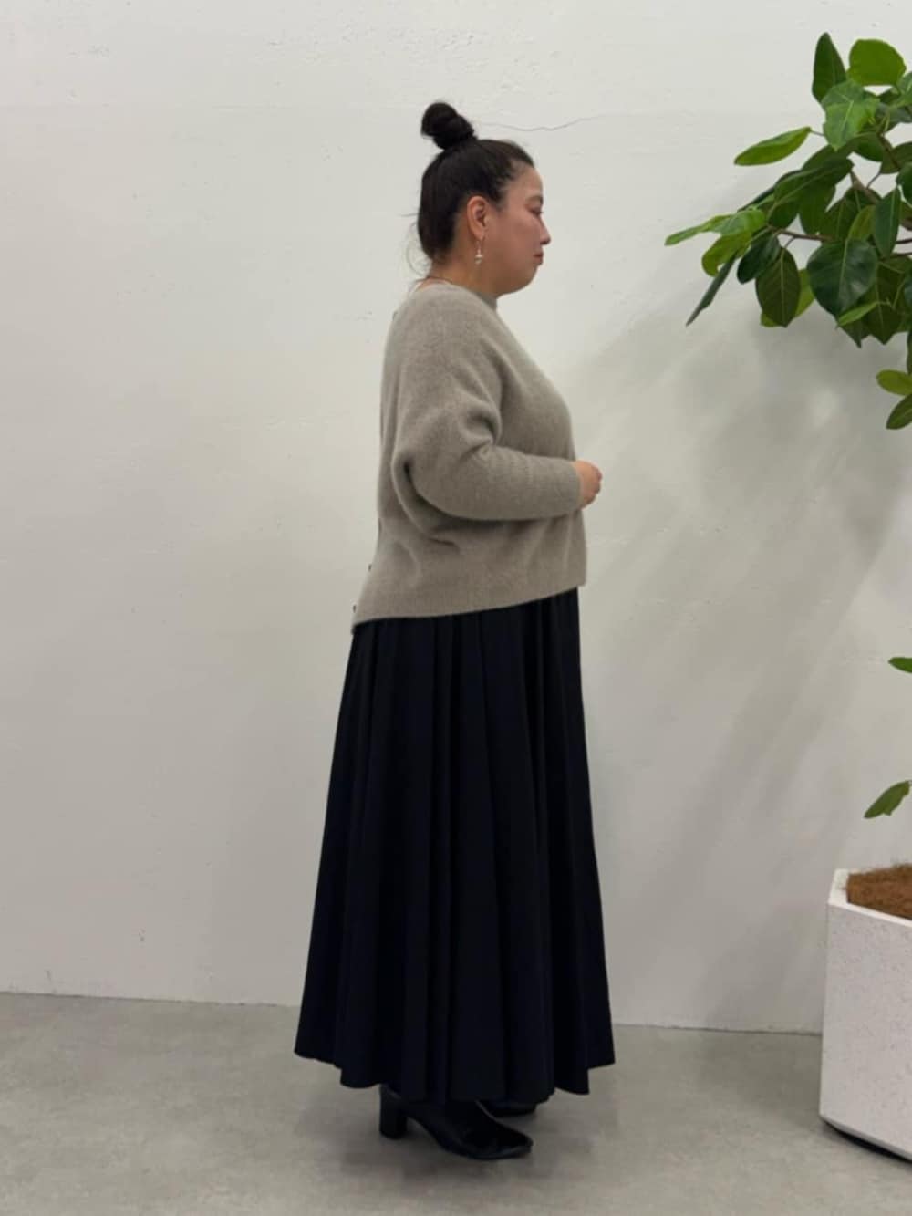 ブラウン系のニット/セーター、ブラック系のトートバッグ、ブラック系のスカートを着用したレディースの秋コーディネートの4枚目の写真