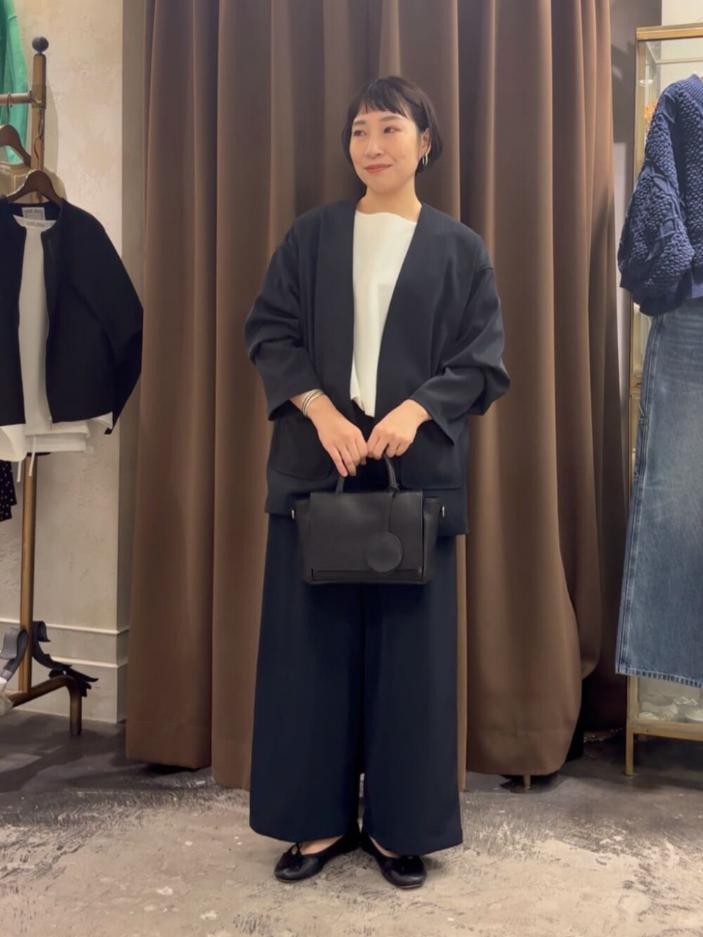 ブラック系のハンドバッグ、ブラック系のその他アウター、ブラック系のその他パンツを着用したレディースの春コーディネートの3枚目の写真