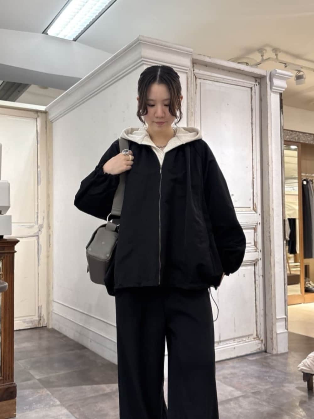 ブラック系のその他パンツ、ホワイト系のパーカー、グレー系のショルダーバッグを着用したレディースの冬コーディネートの4枚目の写真