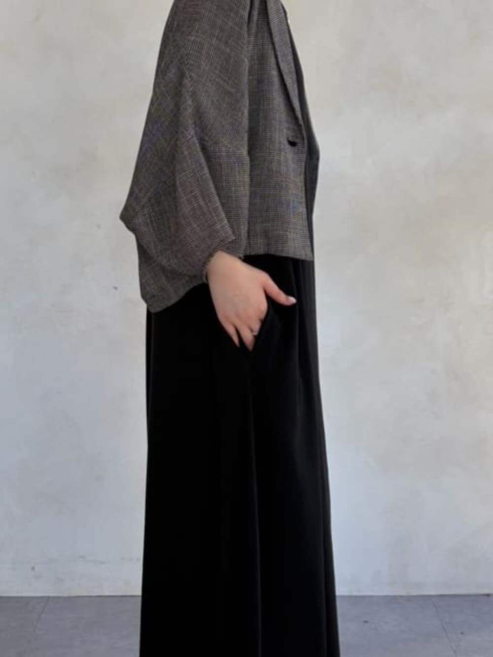 ブラック系のワンピース、ベージュ系のテーラードジャケットを着用したレディースの春コーディネートの6枚目の写真