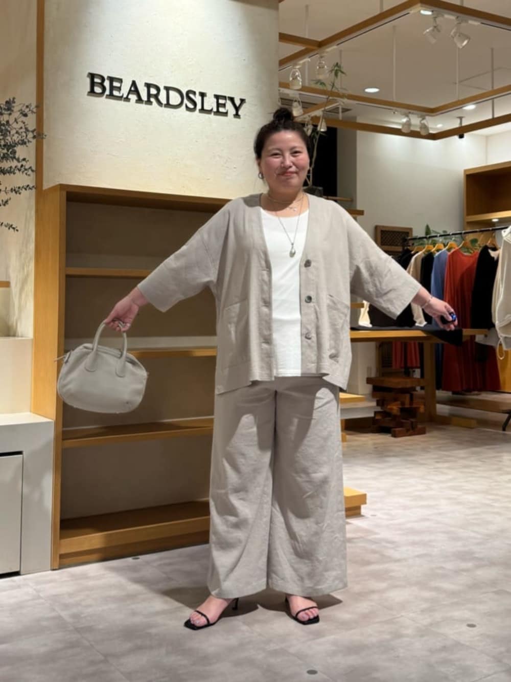 グレー系のボストンバッグ、ホワイト系のシャツ/ブラウス、グレー系のその他パンツを着用したレディースの春コーディネートの3枚目の写真