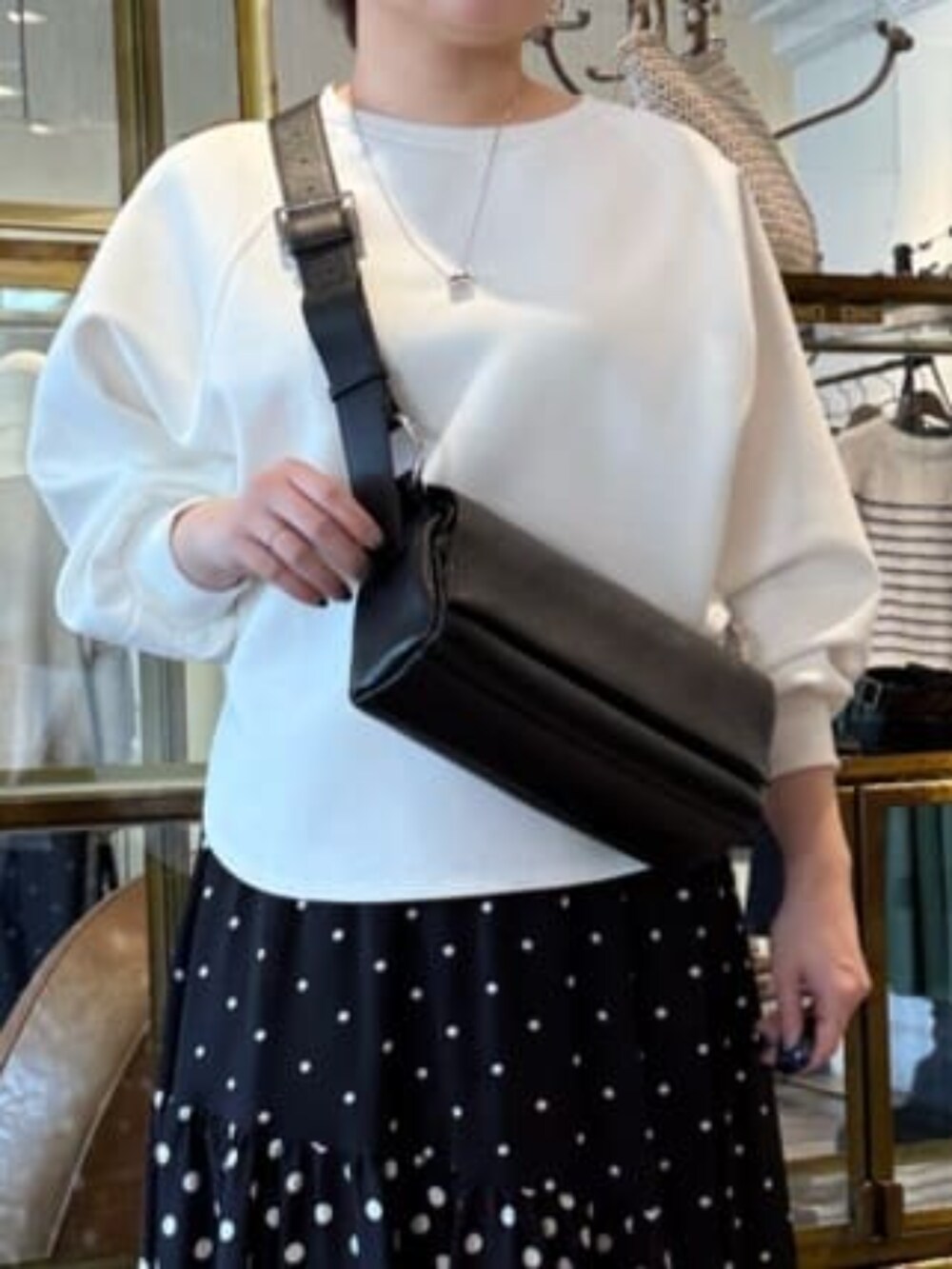 ホワイト系のTシャツ/カットソー、ブラック系のスカートを着用したレディースの冬コーディネートの4枚目の写真