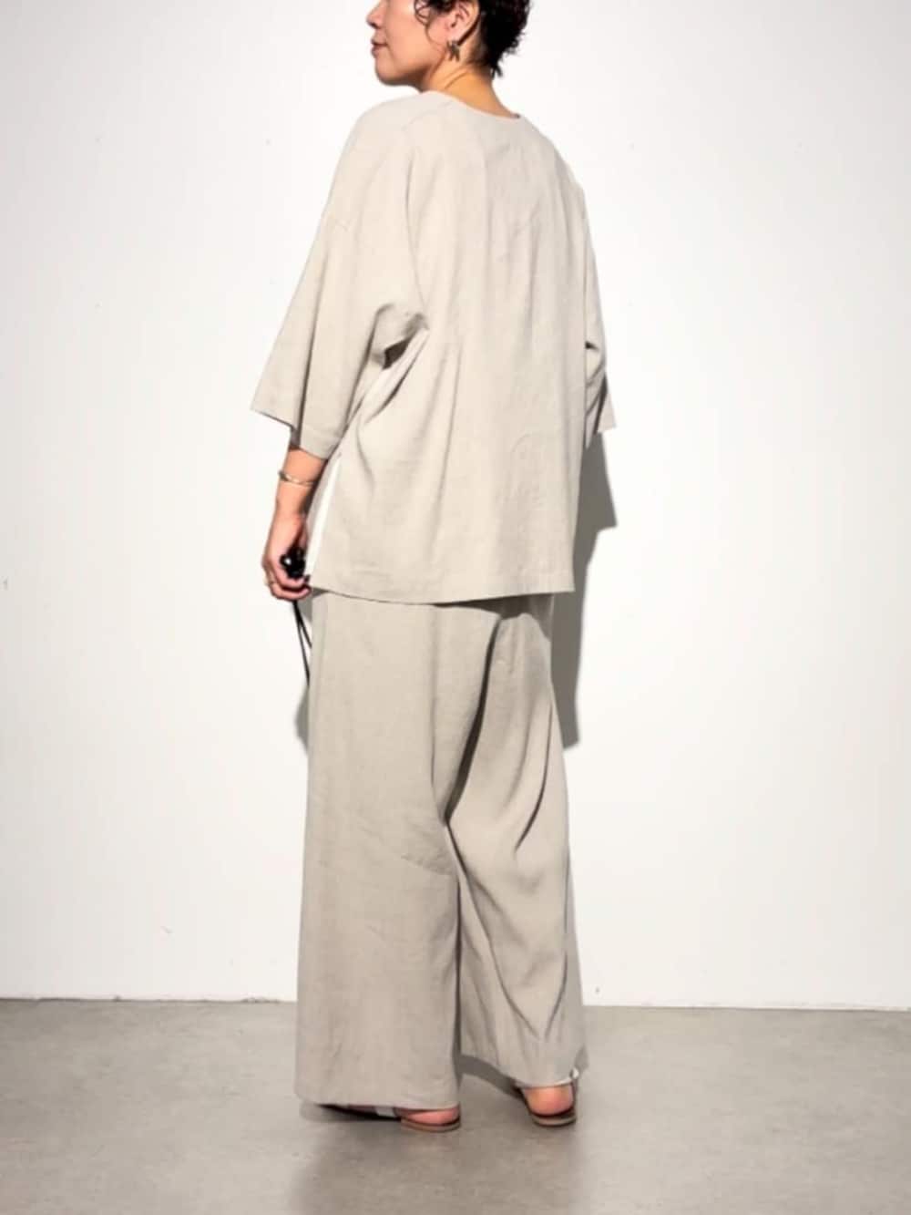 ブラック系のショルダーバッグ、ベージュ系のその他パンツ、ベージュ系のその他アウターを着用したレディースの春コーディネートの7枚目の写真