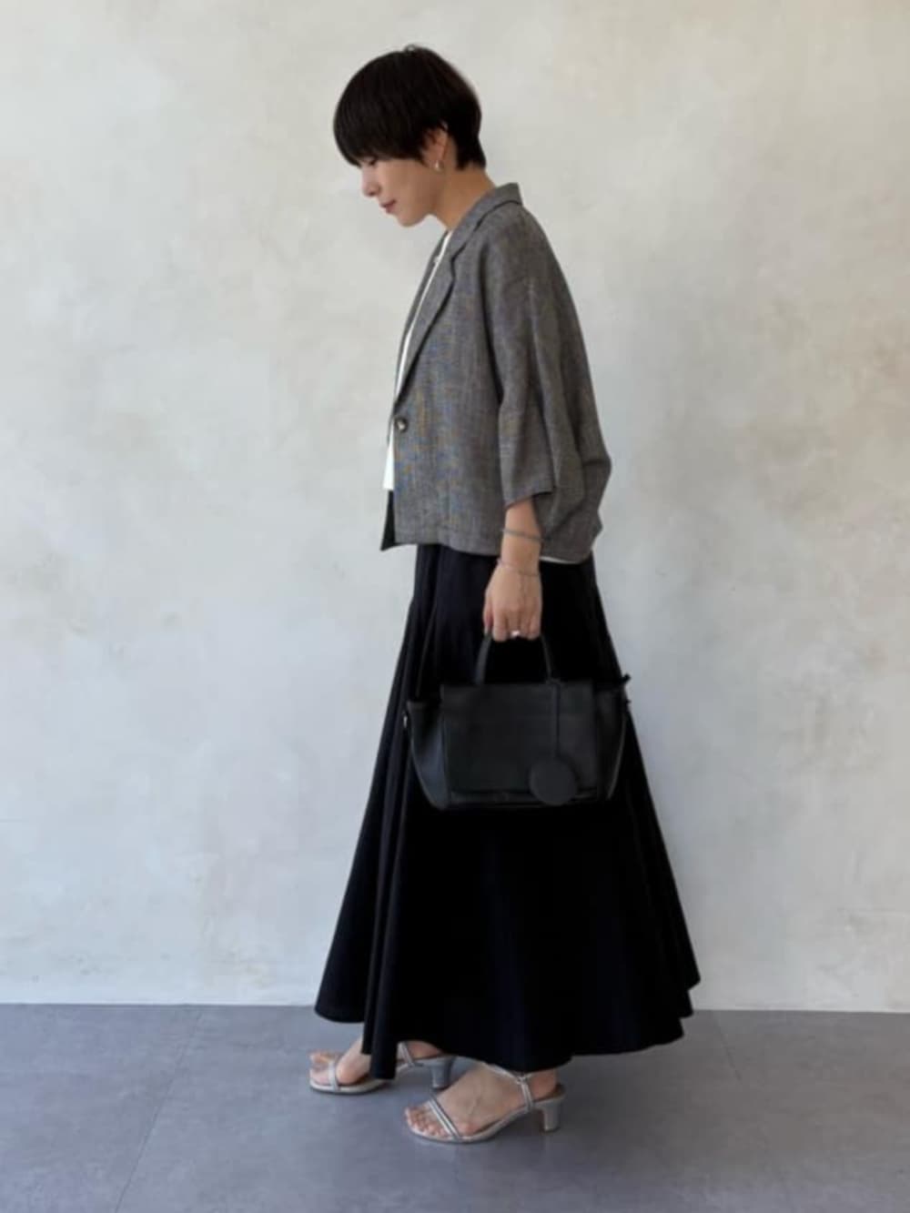 ベージュ系のテーラードジャケット、ホワイト系のシャツ/ブラウス、ブラック系のスカートを着用したレディースの春コーディネートの3枚目の写真