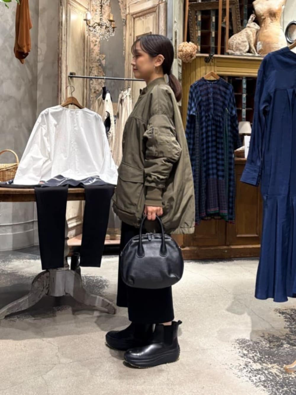 グリーン系のMA-1、ブラック系のスカートを着用したレディースの冬コーディネートの2枚目の写真