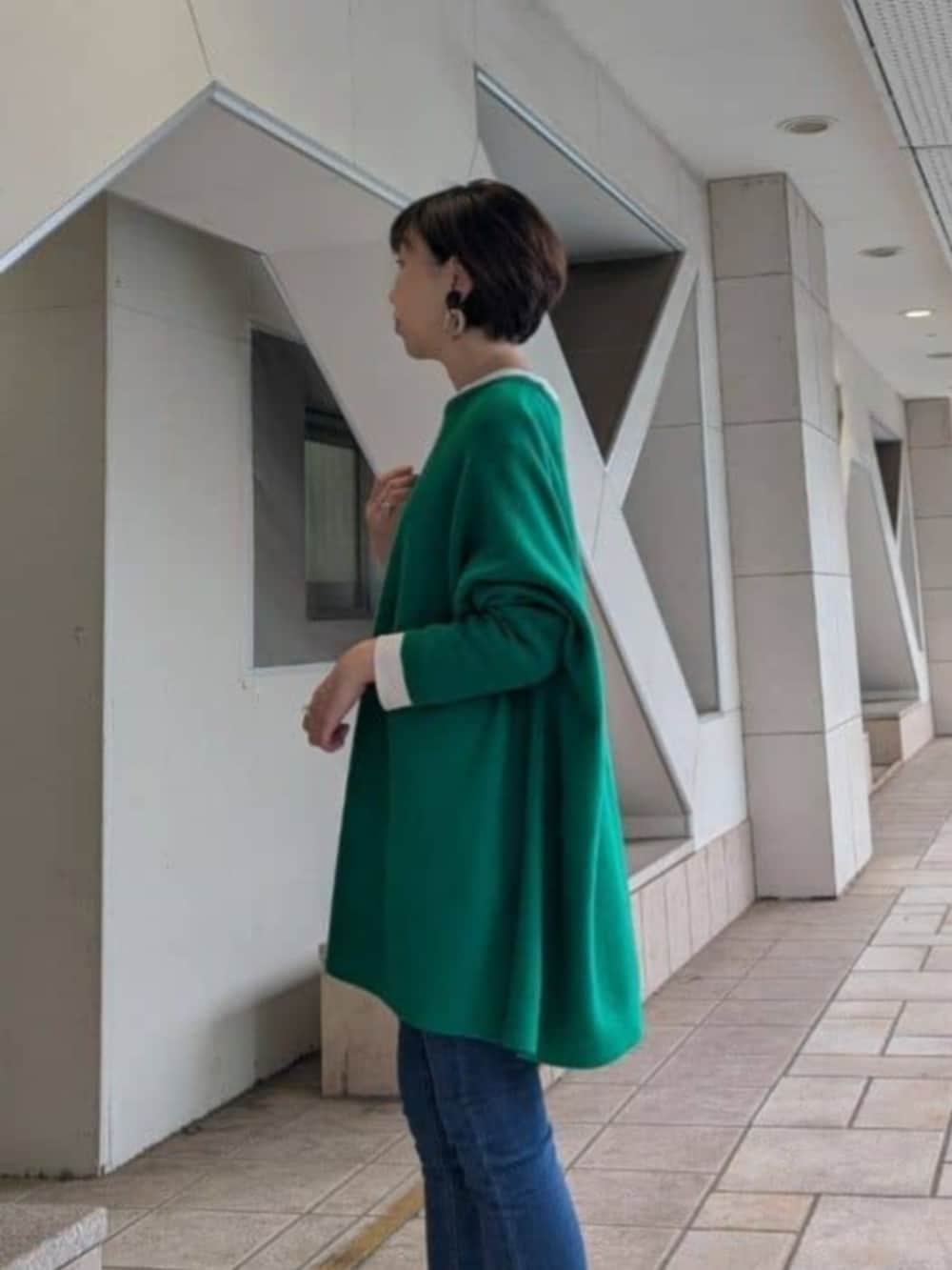 ブルー系のデニムパンツ、ブラウン系のその他シューズ、ブラウン系のトートバッグを着用したレディースの秋コーディネートの4枚目の写真