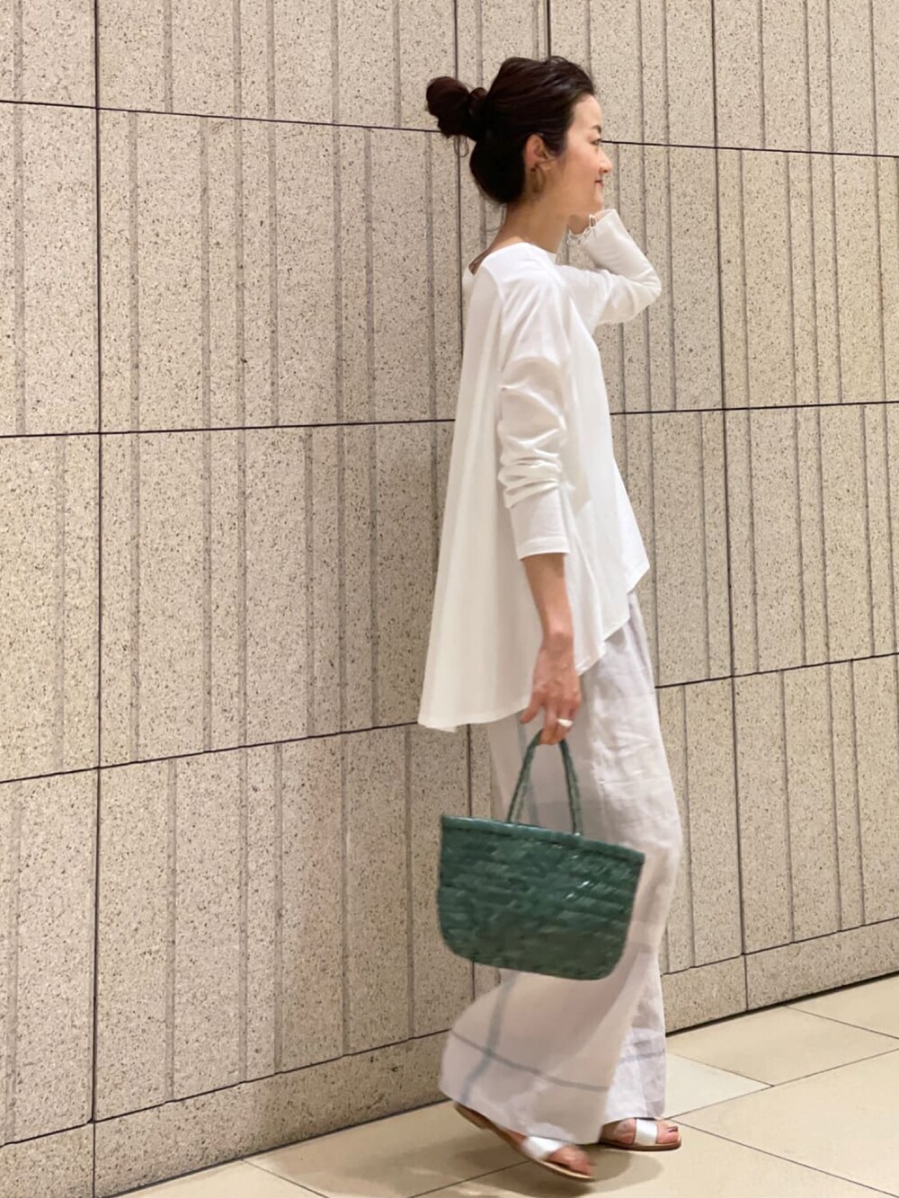 グレー系のその他パンツ、ホワイト系のTシャツ/カットソー、ホワイト系のサンダルを着用したレディースの春コーディネートの2枚目の写真