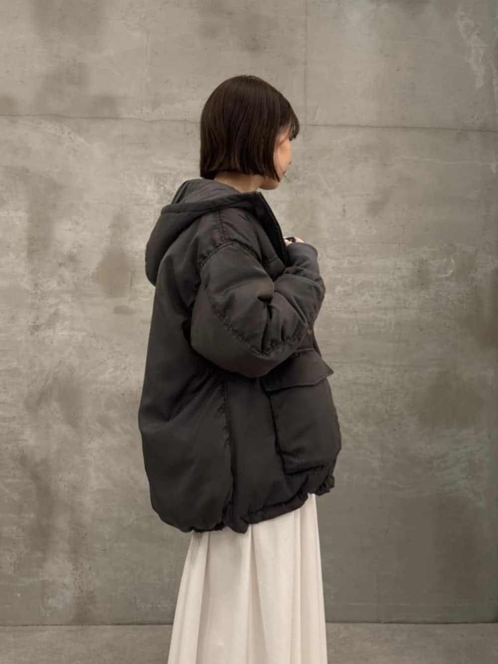 ホワイト系のスカート、グレー系のダウンジャケット/コート、グレー系のTシャツ/カットソーを着用したレディースの秋コーディネートの5枚目の写真