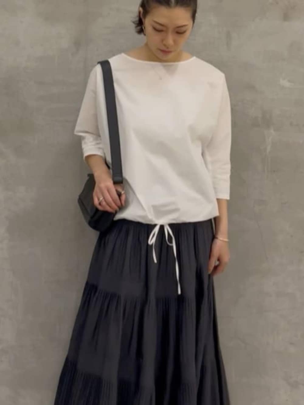 グレー系のスカート、ブラック系のショルダーバッグ、ホワイト系のシャツ/ブラウスを着用したレディースの春コーディネートの8枚目の写真