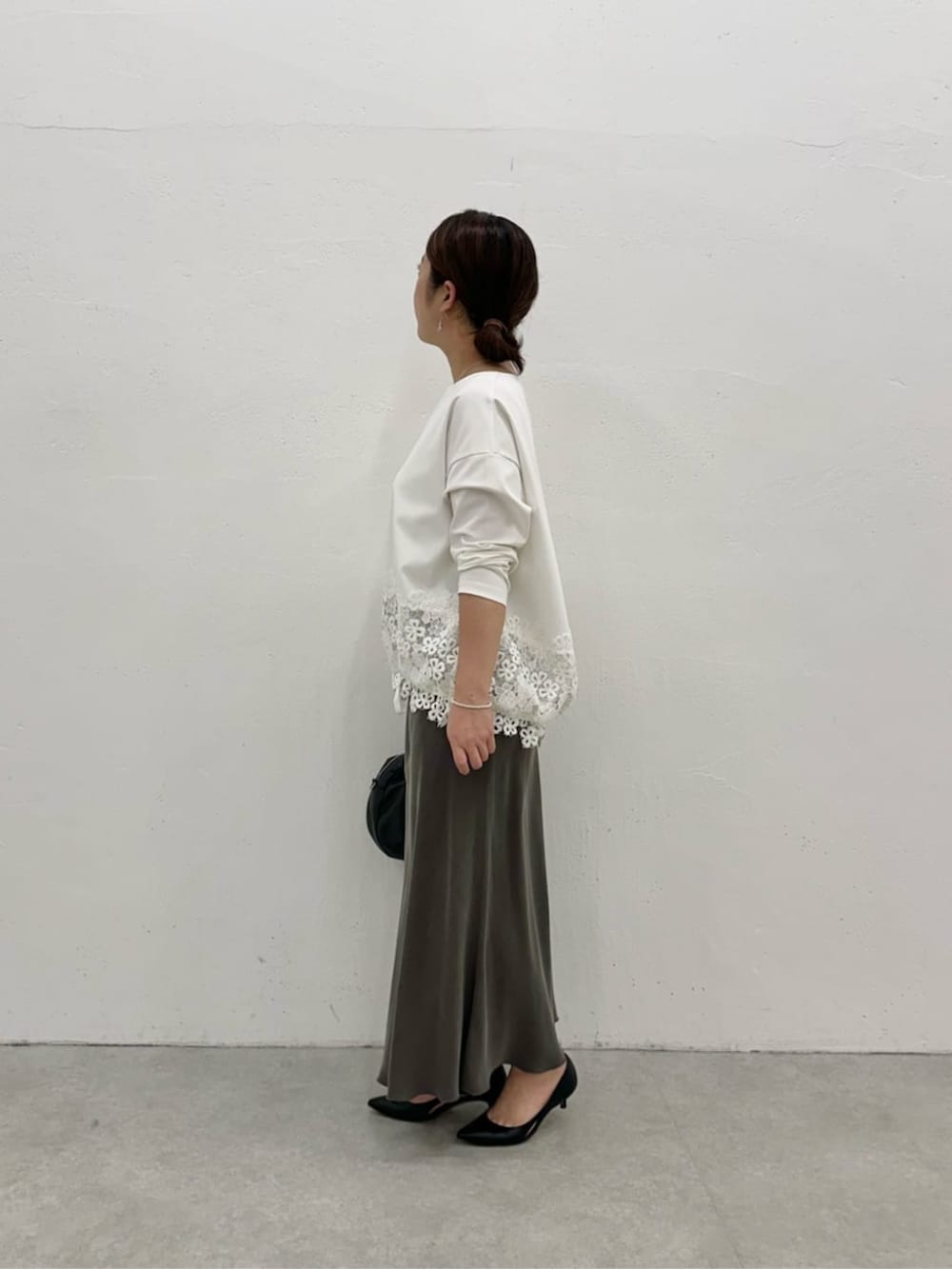 グリーン系のスカート、ホワイト系のTシャツ/カットソーを着用したレディースの冬コーディネートの3枚目の写真