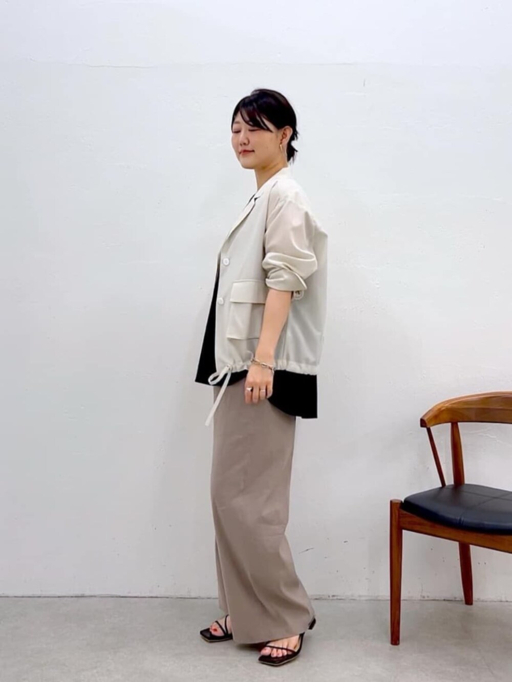 ブラック系のキャミソール、ホワイト系のブルゾン、グレー系のその他パンツを着用したレディースの夏コーディネートの3枚目の写真