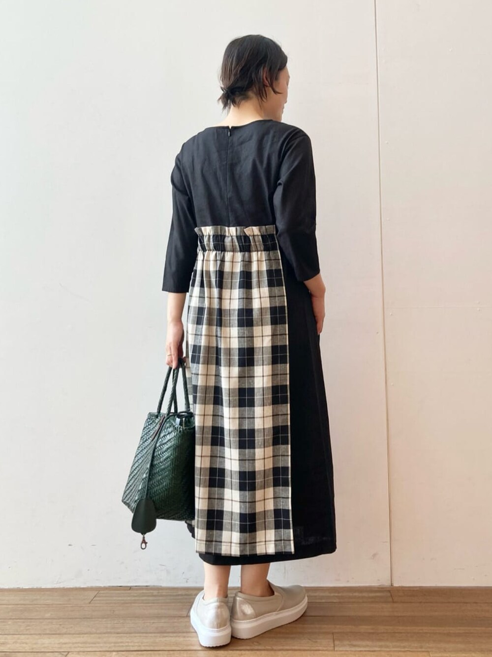 ブラック系のワンピース、グリーン系のトートバッグを着用したレディースの春コーディネートの3枚目の写真