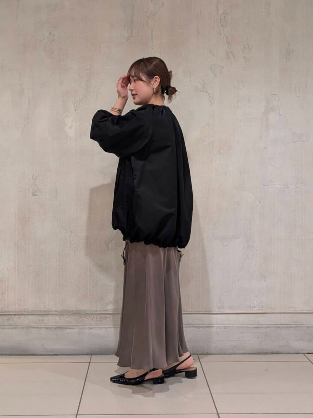 グリーン系のスカート、グレー系のハンドバッグ、ブラック系のノーカラージャケットを着用したレディースの春コーディネートの5枚目の写真