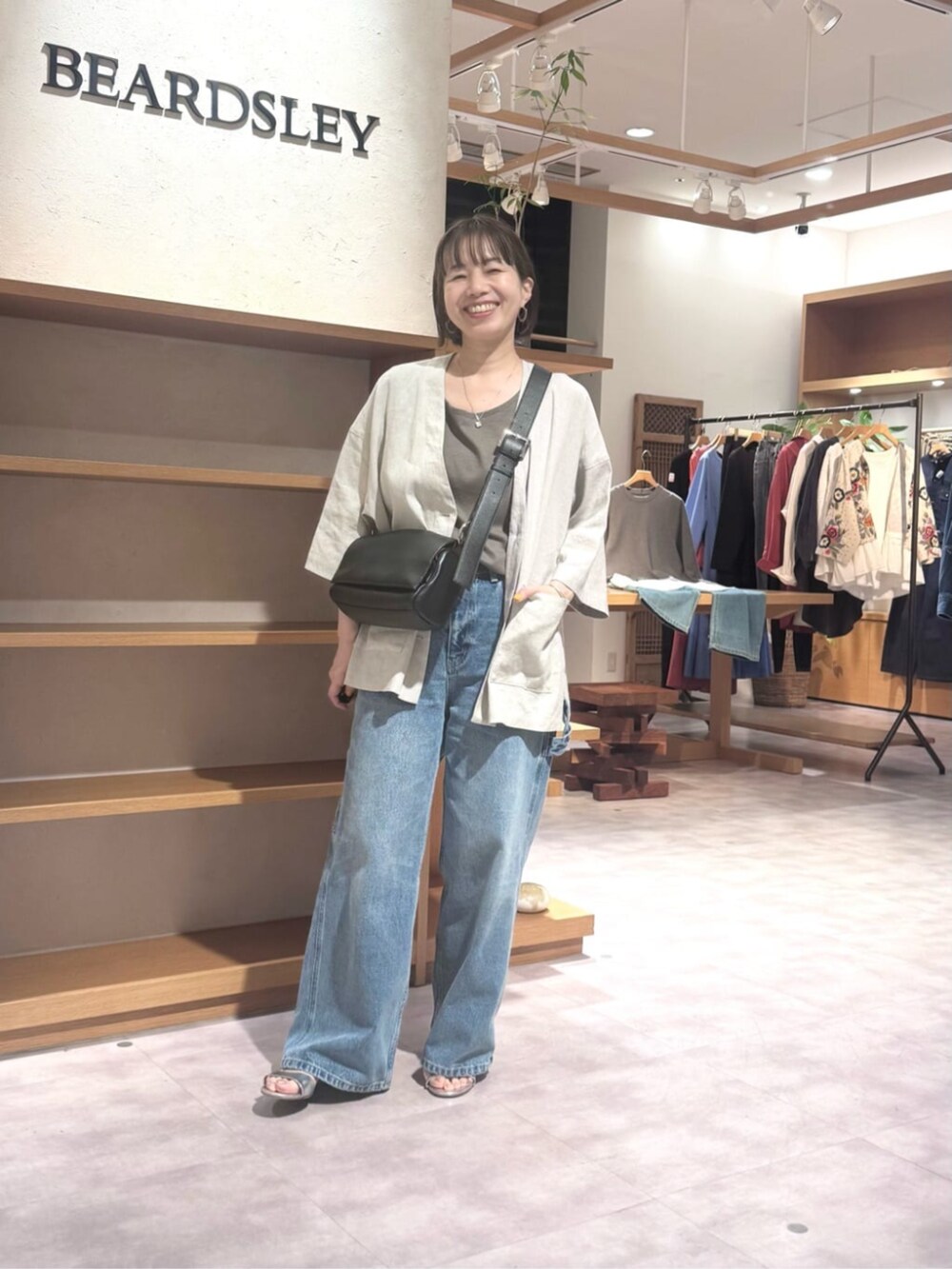 ブラック系のショルダーバッグ、ブルー系のその他パンツ、ブラウン系のキャミソールを着用したレディースの春コーディネートの2枚目の写真